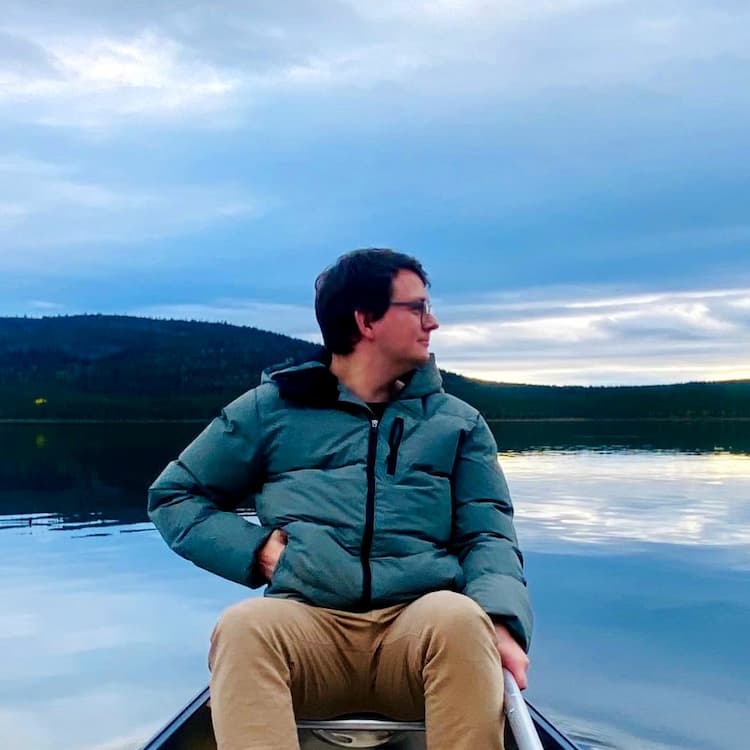 A man sat in a canoe, looking to the right